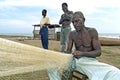 Senior Ghanaian fisherman sits to repair fishnet