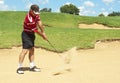 Senior golfer playing golf from sand bunker Royalty Free Stock Photo