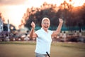 Victory. The senior golfer rejoiced at his victory. Woman on golf filed Royalty Free Stock Photo