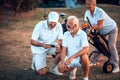 Senior golfers on court. Two men using smart phone Royalty Free Stock Photo