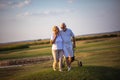 Senior golfers talking and walking on golf course Royalty Free Stock Photo