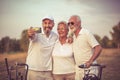 Senior golfers using phone and taking self portrait. Royalty Free Stock Photo