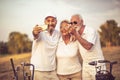 Senior golfers using phone and taking self portrait. Royalty Free Stock Photo