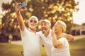 Senior golfers using phone and taking self portrait. Royalty Free Stock Photo