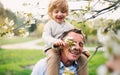 Senior grandfather with toddler grandson standing in nature in spring. Royalty Free Stock Photo