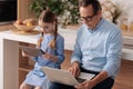 Senior grandfather and young girl surfing Internet at home