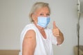 Senior grandmother giving a thumbs up after being vaccinated against Covid-19