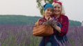 Senior grandmother with granddaughter kid family farmers growing lavender plant in herb garden field