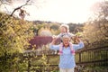 Senior grandmother with toddler granddaughter standing in nature in spring.