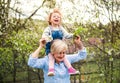 Senior grandmother with toddler granddaughter standing in nature in spring. Royalty Free Stock Photo