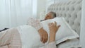 Senior grandparents couple lying and sleeping in bed. Woman getting disturbed with man snoring Royalty Free Stock Photo