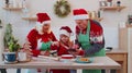 Senior grandparents and grandchild watching cooking lesson using digital tablet at Christmas kitchen Royalty Free Stock Photo