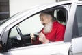 Senior with a gray beard is sitting in the car and holding a photo camera Royalty Free Stock Photo