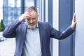 Senior gray haired man businessman upset and desperate outside office building