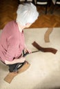 Senior gray-haired woman vacuuming floors in her living room Royalty Free Stock Photo