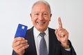 Senior grey-haired businessman holding credit card over isolated white background surprised with an idea or question pointing Royalty Free Stock Photo