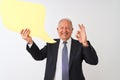 Senior grey-haired businessman holding speech bubble over isolated white background doing ok sign with fingers, excellent symbol Royalty Free Stock Photo