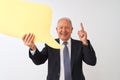 Senior grey-haired businessman holding speech bubble over isolated white background surprised with an idea or question pointing Royalty Free Stock Photo