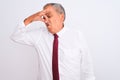 Senior grey-haired businessman wearing elegant tie over isolated white background smelling something stinky and disgusting, Royalty Free Stock Photo