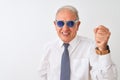 Senior grey-haired businessman wearing tie and sunglasses over isolated white background annoyed and frustrated shouting with Royalty Free Stock Photo