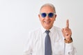 Senior grey-haired businessman wearing tie and sunglasses over isolated white background surprised with an idea or question Royalty Free Stock Photo