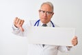 Senior grey-haired doctor man holding banner standing over isolated white background with angry face, negative sign showing Royalty Free Stock Photo