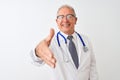 Senior grey-haired doctor man wearing stethoscope standing over isolated white background smiling friendly offering handshake as Royalty Free Stock Photo