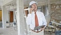 Senior grey-haired man architect talking on smartphone looking around at construction site Royalty Free Stock Photo