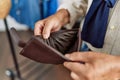 Senior grey-haired man showing empty wallet at clothing store Royalty Free Stock Photo
