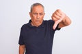 Senior grey-haired man wearing black casual polo standing over isolated white background looking unhappy and angry showing Royalty Free Stock Photo