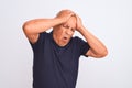 Senior grey-haired man wearing black casual polo standing over isolated white background suffering from headache desperate and Royalty Free Stock Photo