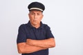 Senior grey-haired man wearing black polo and captain hat over isolated white background skeptic and nervous, disapproving Royalty Free Stock Photo