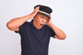 Senior grey-haired man wearing black polo and captain hat over isolated white background suffering from headache desperate and Royalty Free Stock Photo