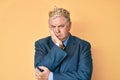 Senior grey-haired man wearing business suit and king crown thinking looking tired and bored with depression problems with crossed