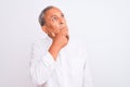 Senior grey-haired man wearing elegant shirt standing over isolated white background with hand on chin thinking about question, Royalty Free Stock Photo
