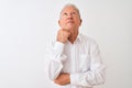 Senior grey-haired man wearing elegant shirt standing over isolated white background with hand on chin thinking about question, Royalty Free Stock Photo