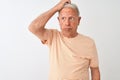 Senior grey-haired man wearing striped t-shirt standing over isolated white background confuse and wondering about question Royalty Free Stock Photo