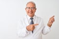 Senior grey-haired scientist man wearing coat standing over isolated white background smiling and looking at the camera pointing Royalty Free Stock Photo