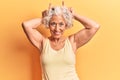 Senior grey-haired woman wearing casual clothes doing funny gesture with finger over head as bull horns