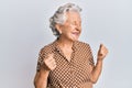 Senior grey-haired woman wearing casual clothes excited for success with arms raised and eyes closed celebrating victory smiling Royalty Free Stock Photo