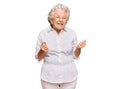 Senior grey-haired woman wearing casual clothes excited for success with arms raised and eyes closed celebrating victory smiling Royalty Free Stock Photo