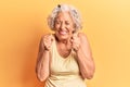 Senior grey-haired woman wearing casual clothes excited for success with arms raised and eyes closed celebrating victory smiling Royalty Free Stock Photo