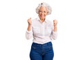 Senior grey-haired woman wearing casual clothes excited for success with arms raised and eyes closed celebrating victory smiling Royalty Free Stock Photo