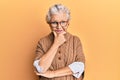 Senior grey-haired woman wearing casual clothes and glasses looking confident at the camera smiling with crossed arms and hand Royalty Free Stock Photo