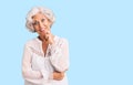 Senior grey-haired woman wearing casual clothes looking confident at the camera with smile with crossed arms and hand raised on Royalty Free Stock Photo