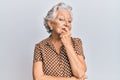 Senior grey-haired woman wearing casual clothes looking confident at the camera with smile with crossed arms and hand raised on Royalty Free Stock Photo