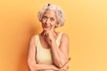Senior grey-haired woman wearing casual clothes looking confident at the camera smiling with crossed arms and hand raised on chin Royalty Free Stock Photo