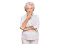 Senior grey-haired woman wearing casual clothes looking confident at the camera smiling with crossed arms and hand raised on chin Royalty Free Stock Photo