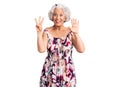 Senior grey-haired woman wearing casual clothes showing and pointing up with fingers number eight while smiling confident and Royalty Free Stock Photo