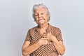 Senior grey-haired woman wearing casual clothes smiling with hands on chest with closed eyes and grateful gesture on face Royalty Free Stock Photo